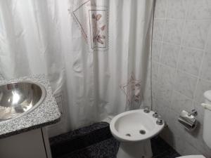 łazienka z umywalką, toaletą i zasłoną prysznicową w obiekcie Departamento Montevideana w mieście Villa Mercedes