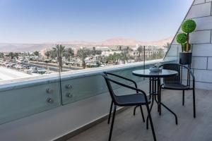 a table and chairs on a balcony with a view at Sea side "Rose" apartment - by Rently in Eilat
