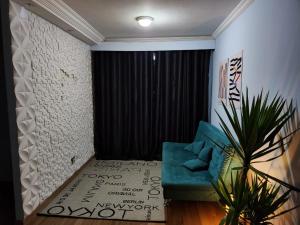 a living room with a blue couch and a black curtain at Apê perto Alphaville in Osasco +8 photos