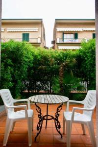 un patio con mesa, 2 sillas y una mesa en Bilocale con giardino al centro a Sirolo - S075 en Sirolo