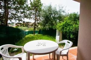 una mesa blanca y sillas en un patio en Bilocale con giardino al centro a Sirolo - S075 en Sirolo