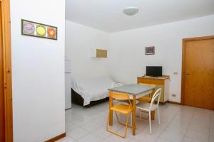 Habitación con escritorio, mesa y cama. en Bilocale con giardino al centro a Sirolo - S075 en Sirolo