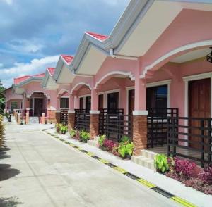 a pink building with flowers in front of it at Kojie Guest House in Moalboal