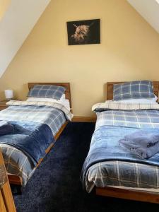 dwa łóżka siedzące obok siebie w sypialni w obiekcie Scottish Highland house near Fort William w mieście Corran