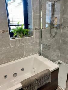 a bathroom with a white tub and a shower at Scottish Highland house near Fort William in Corran