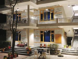 a building with stairs and a table and chairs at The Royal Orchard Kasol in Kasol