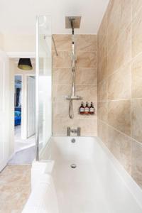 a bathroom with a bath tub with a shower at Glara's Boutique in Roughhill