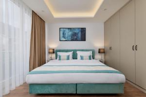 a bedroom with a large bed with a blue headboard at Hotel Splendido Bay in Tivat