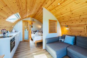 The Stag Pod Farm Stay with Hot Tub Sleeps 2 Ayrshire Rural Retreats في Galston: غرفة معيشة مع أريكة وغرفة نوم