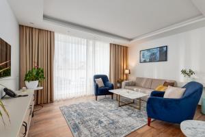 uma sala de estar com um sofá, cadeiras e uma mesa em Hotel Splendido Bay em Tivat