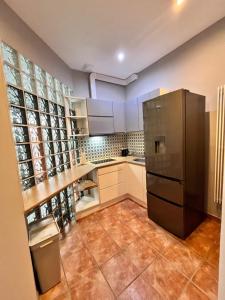 una cucina con frigorifero in acciaio inox e pavimenti piastrellati di Apartament ORZEŁ BIAŁY a Bytom