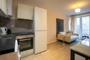 a kitchen with a refrigerator and a living room at North London - one bed flat- entire unit in London