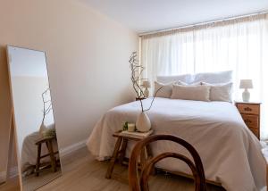 a bedroom with a bed with a mirror and a chair at North London - one bed flat- entire unit in London