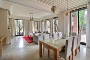 - une salle à manger avec une table et un canapé dans l'établissement Villa de luxe Kasbah Amazigh, à Marrakech