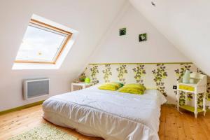 een slaapkamer met een bed met gele kussens en een raam bij Le Domaine de Kerampape, gîte accessible, vignoble en Finistère sud in Pouldergat