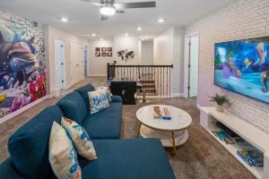 a living room with a blue couch and a tv at Luxury Lake View 9-Bedroom Villa @Storey Lake Resort in Kissimmee
