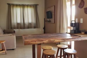 a living room with a large wooden table and stools at Canto do Paraíso - Aluguel para Temporada in Alto Paraíso de Goiás