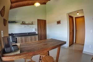 a kitchen with a wooden table in a room at Canto do Paraíso - Aluguel para Temporada in Alto Paraíso de Goiás