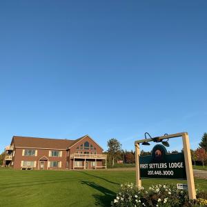 a first settlers lodge sign in front of a building at First Settlers Lodge in Weston