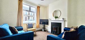 uma sala de estar com dois sofás azuis e um espelho em Bedford Street by Switchback Stays em Cardiff