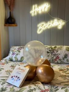 einen Ballon auf einem Haufen Bälle auf einem Bett in der Unterkunft The Stag Pod Farm Stay with Hot Tub Sleeps 2 in Galston