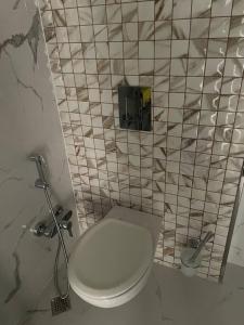 a bathroom with a toilet and a tiled wall at Spacious 3 bedroom with sea view in Baku