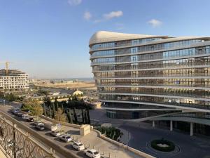 a large building with cars parked in a parking lot at Spacious 3 bedroom with sea view in Baku