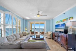 ein Wohnzimmer mit Sofa und Flachbildfernseher in der Unterkunft Beach Colony Tower 14A in Pensacola