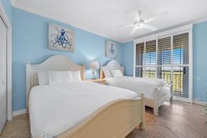 2 Betten in einem Schlafzimmer mit blauen Wänden in der Unterkunft Beach Colony Tower 14A in Pensacola + 42 Fotos