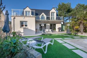 Casa con patio con sillas y sombrilla en Instants de detente, piscine et calme, en Le Pouliguen