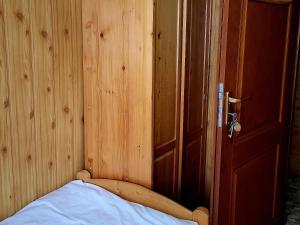 a wooden room with a bed and a wooden door at Domek w Górach in Korbielów