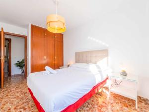 una camera con un grande letto bianco e una scrivania di A un minuto de la palaya con parking y terraza a Málaga