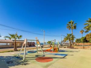 un parco giochi vuoto con scivoli e altalene di A un minuto de la palaya con parking y terraza a Málaga