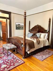 um quarto com uma grande cama de madeira e um tapete em MacFie House em Cape Girardeau