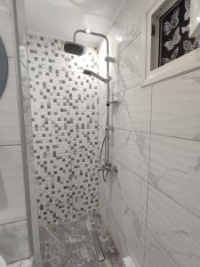 a bathroom with a shower with white tiles at KSP1STUDIO in Perea