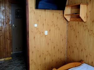 a room with a wooden wall with a bed in it at Domek w Górach in Korbielów