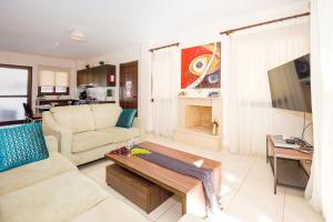 ein Wohnzimmer mit einem Sofa und einem Tisch in der Unterkunft Villa Ioanna - 50m from Med Sea in Ayia Napa