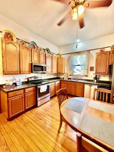 a kitchen with wooden cabinets and a dining room table at MacFie House in Cape Girardeau