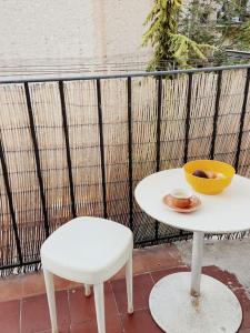 a white table and a chair and a bowl of fruit at Marina Motel in Marseille