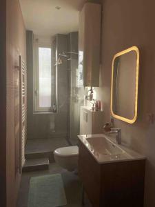 een badkamer met een wastafel, een toilet en een spiegel bij Marina Motel in Marseille