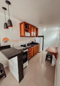uma cozinha com um fogão e um frigorífico branco em Arraial do Cabo Village Pôr Do Sol em Arraial do Cabo