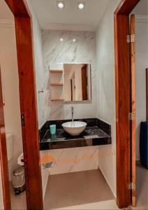a bathroom with a sink and a mirror at Arraial do Cabo Village Pôr Do Sol in Arraial do Cabo