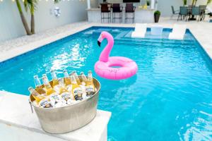 un seau de bière et un flamingo rose dans une piscine dans l'établissement Lux Backyard/Heated Pool/Everglades/Speedway/Keys!, à Miami