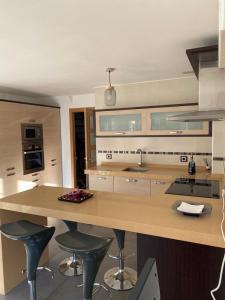 a kitchen with a large island with stools in it at El mirador de cudillero in Cudillero