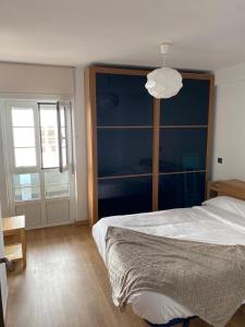 a bedroom with a large bed and a large window at El mirador de cudillero in Cudillero