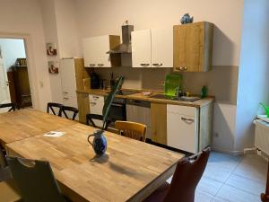 eine Küche mit einem Holztisch mit einer Vase darauf in der Unterkunft Gwuni B&B in Leipzig