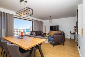 een woonkamer met een tafel en stoelen en uitzicht bij SkyView Penthouse Apartment by MHM in Funchal