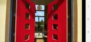 a red door with a view of a room at Captiva Wexford - Your Ultimate Luxury Family Villa Getaway in Kilmuckridge