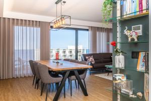 een woonkamer met een tafel en stoelen en een bank bij SkyView Penthouse Apartment by MHM in Funchal