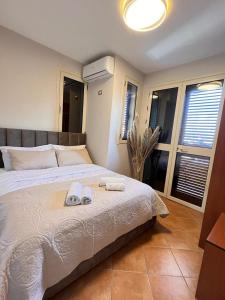 a bedroom with a bed with two towels on it at Belix Hotel Apartments, Near the Beach in Durrës